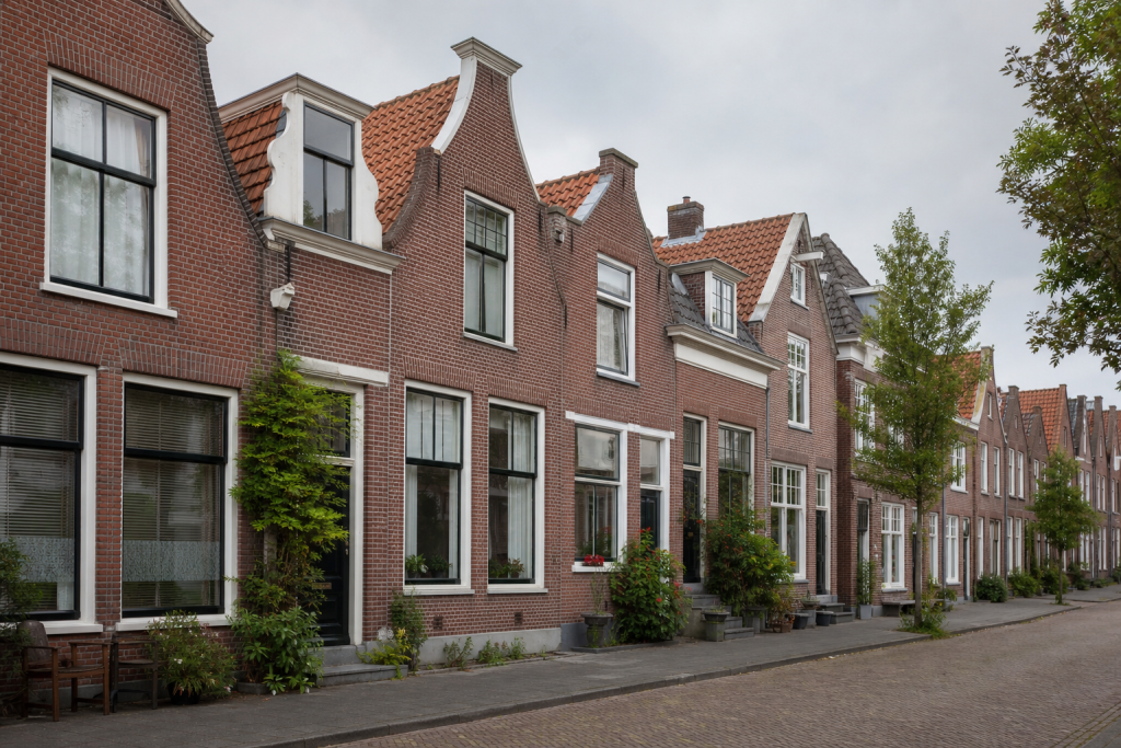 Rij Nederlandse rijtjeshuizen aan een rustige straat